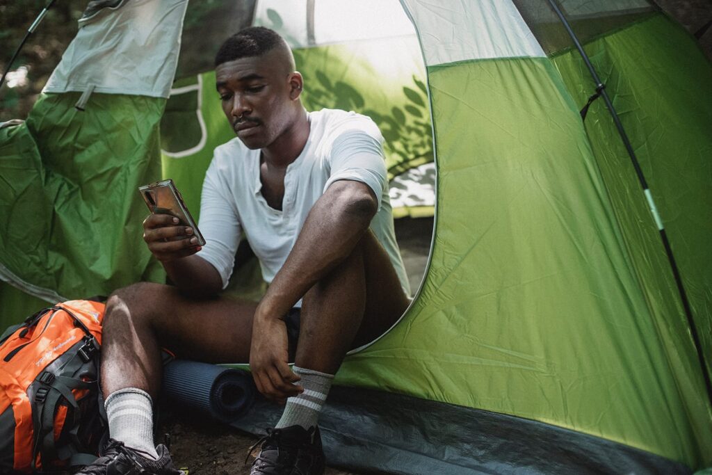 Male using power bank in hiking tent